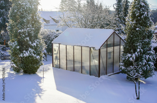 Ein Gewächshaus im Winter mit viel Schnee im Garte Eigenheim
