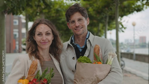 Happy family holding gorcery bags while standing on street photo