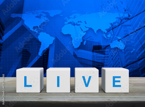 Fototapeta Naklejka Na Ścianę i Meble -  Live letter on white block cubes on wooden table over world map, modern office city tower and skyscraper, Technology broadcasting communication concept, Elements of this image furnished by NASA