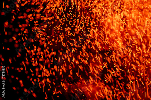 Flying sparks of flame on a dark background abstract image