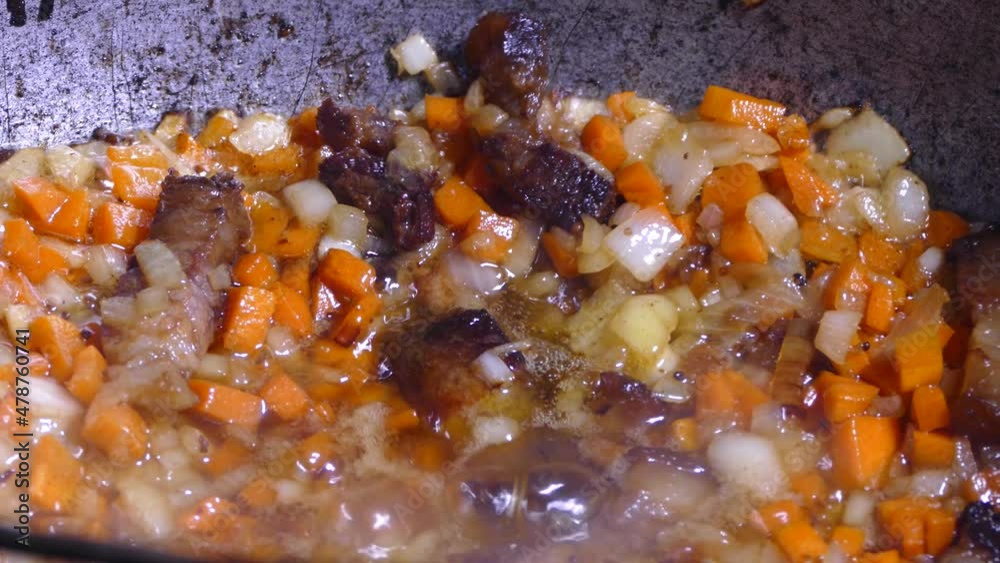 Frying is being prepared with seasoning for a meat dish. Kitchen in a cauldron. Stir with a kitchen spatula. Frying is being prepared with seasoning for a meat dish. Kitchen in a cauldron. Stir with a kitchen spatula.