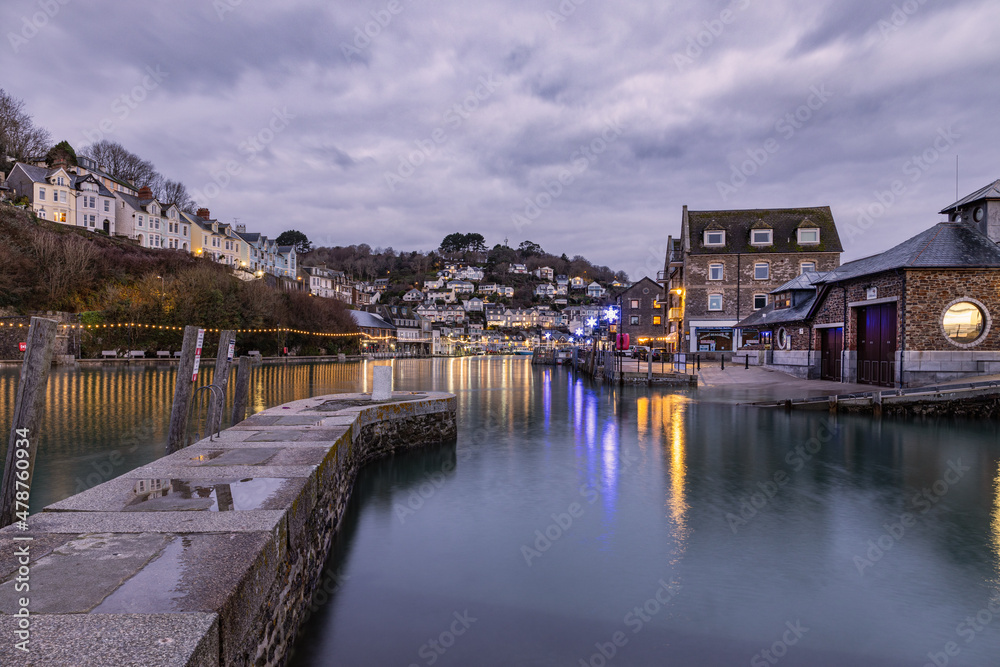 a winters sunrise in Looe Harbour with reflections in the water
