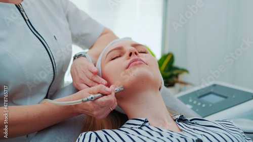 Close up of young woman getting vacuum microdermabrasion. Peeling treatment at cosmetic beauty spa clinic.