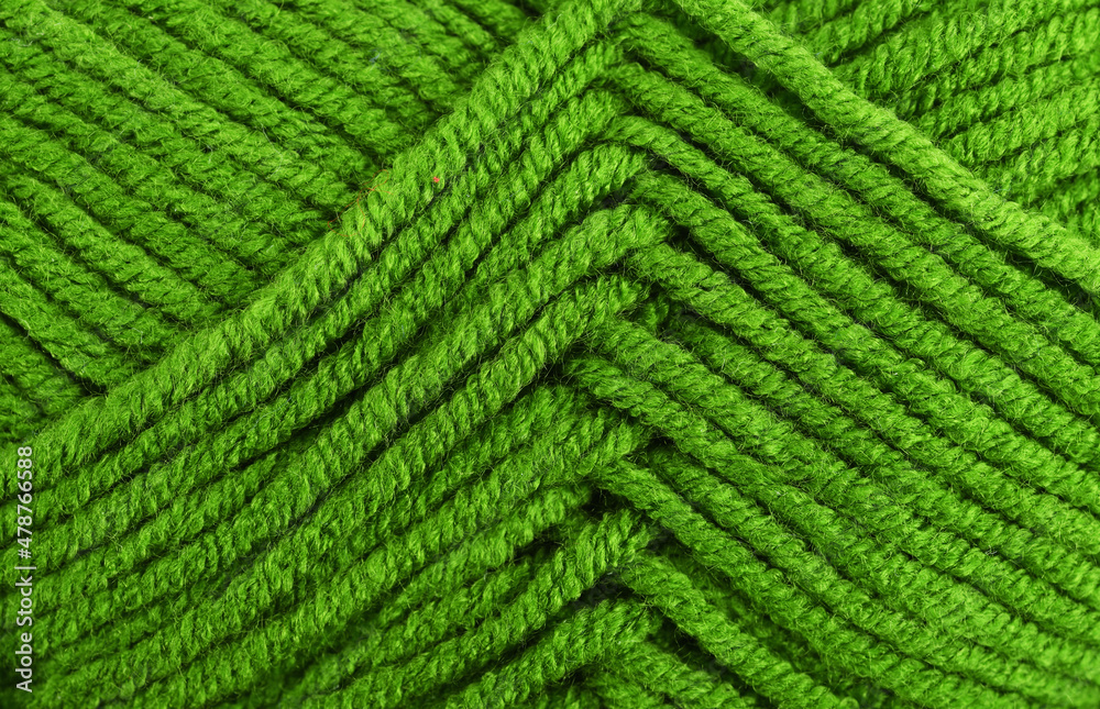 Green knitting wool close-up.Green yarn clew close up texture. Blue wool background. Green knitting wool close-up.Green yarn clew close up texture. Blue wool background.