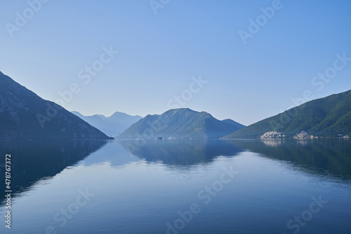Morning seascape, reflection of mountains in sea water in Montenegro