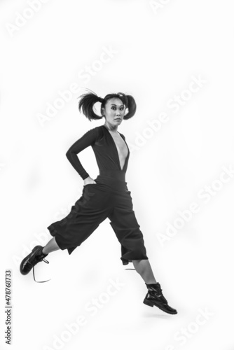 Korean woman with pigtails jumping on a white background