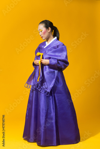 Korean woman in yellow background with traditional dress of her country