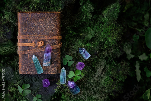 witches book and crystal minerals on dark natural background. Healing gemstones for magic Crystal Ritual, Witchcraft, spiritual esoteric practice. top view photo