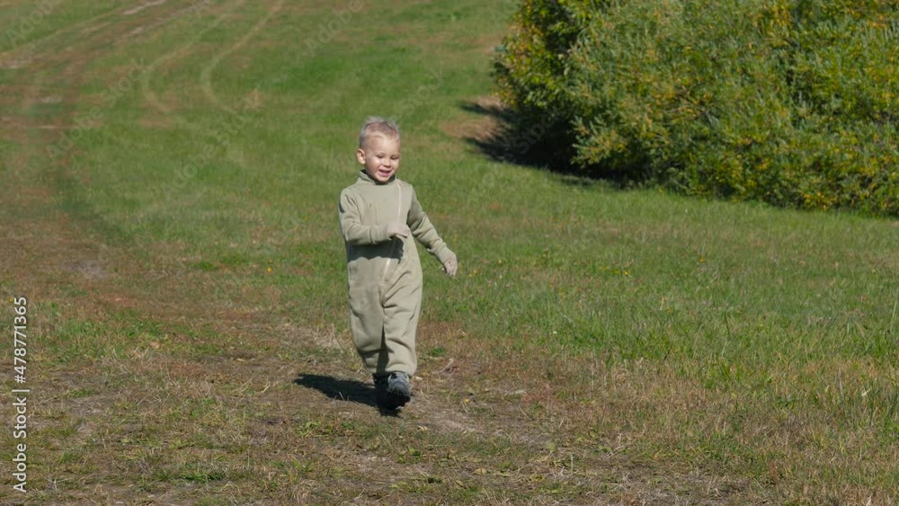 Funny Smiling Child Running Down Slide On Green Field On Autumn Sunny Day Funny Smiling Child Running Down Slide On Green Field On Autumn Sunny Day