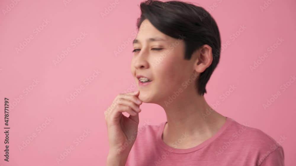 Pensive Asian man thinking about something in the pink studio Pensive Asian man thinking about something in the pink studio