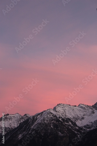 Purple and pink sunset over snow capped alpine mountains (Aosta, Italy). Stunning alpine snowy mountain winter phone, portrait screensaver or wallpaper background