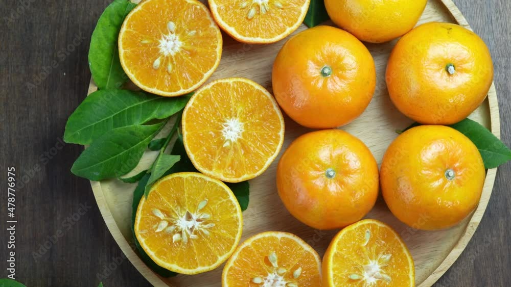 Fresh Tangerine Orange with slices on wooden plate, Mandarin Orange fruit in wooden plate on wooden table in garden. Fresh Tangerine Orange with slices on wooden plate, Mandarin Orange fruit in wooden plate on wooden table in garden.
