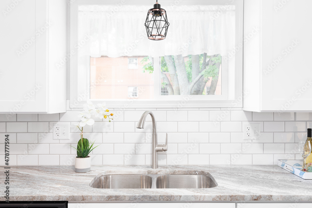 Kitchen sink detail shot with a marble countertop, white