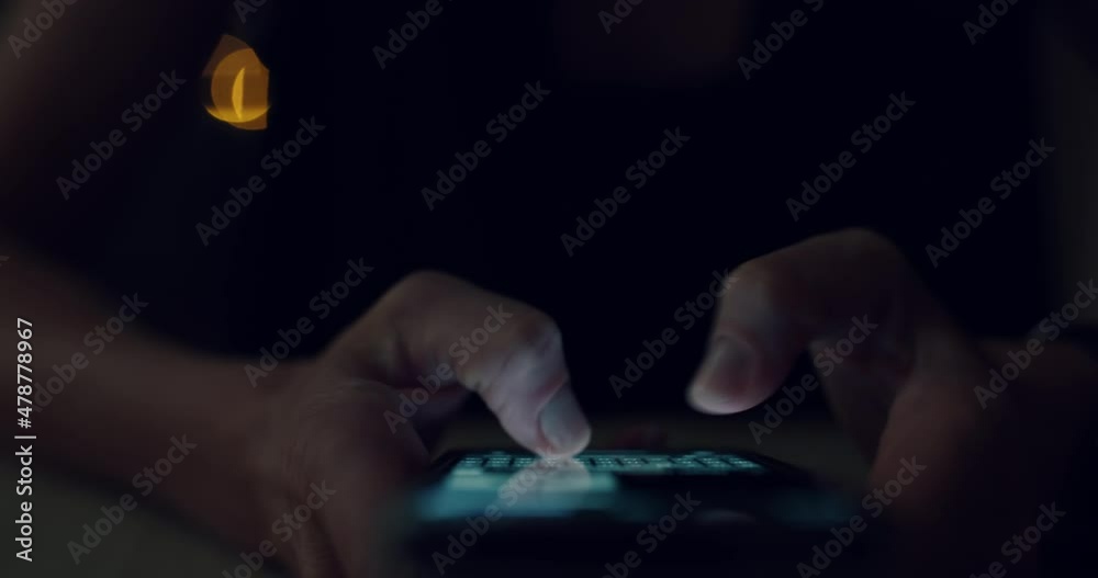 Closeup of woman type fast a message on her phone screen, text with friends or use social media in darkness. Female fingers type text on touchscreen of smartphone