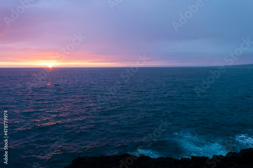 Beautiful and calm sunset over the ocean with some clouds