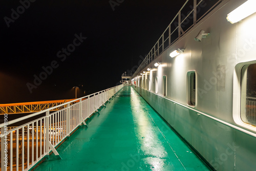 Promenade deck of a ro-ro ship and cruiseferry in the harbor of Ystad at night. The ferry connects the city of Świnoujście in Poland and Ystad in Sweden