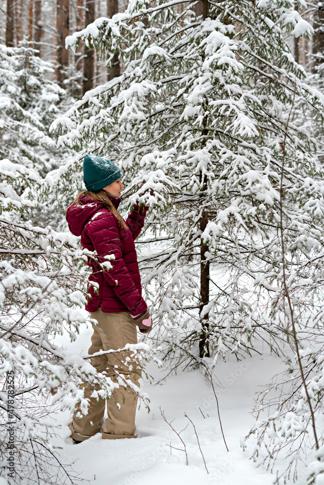 young woman in red jacket walking in winter snowy coniferous forest, beauty in nature, active lifestyle winter hiking