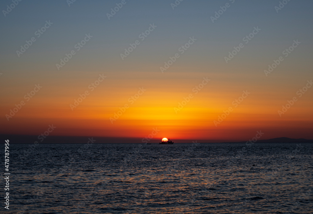 Silhouette of boat on sea beach with sunset background. Sunset moment at the sea side in Neos Marmaras, Greece.