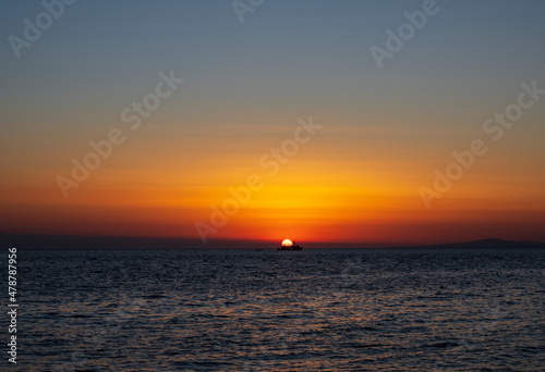 Silhouette of boat on sea beach with sunset background. Sunset moment at the sea side in Neos Marmaras, Greece. © Bojan