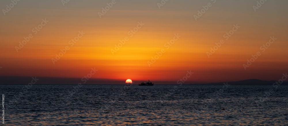 Silhouette of boat on sea beach with sunset background. Sunset moment at the sea side in Neos Marmaras, Greece.