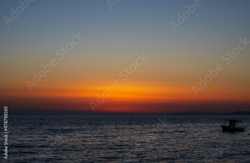 Silhouette of boat on sea beach with sunset background. Sunset moment at the sea side in Neos Marmaras, Greece. © Bojan