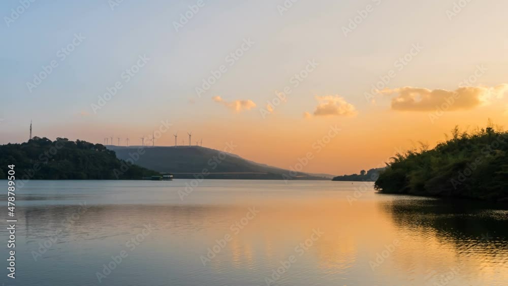 Time lapse Landscape of Mountain and lake scenery with wind turbine and motorway at sunrise at Lam Ta Khong dam, Nakhon Ratchasima, Thailand Time lapse Landscape of Mountain and lake scenery with wind turbine and motorway at sunrise at Lam Ta Khong dam, Nakhon Ratchasima, Thailand