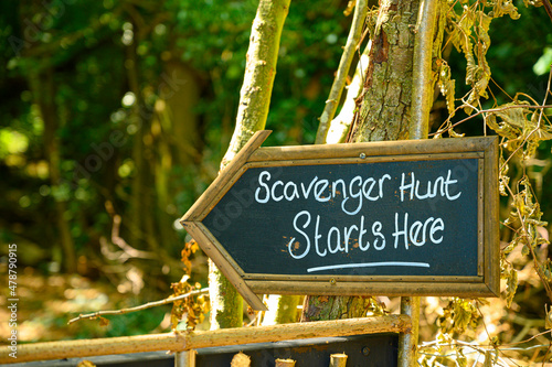 Scavenger hunt sign in lush forest woodland