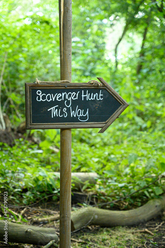 Scavenger hunt sign in lush forest woodland