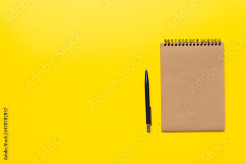 school brown notebook on a colored background, spiral craft notepad on a table Top view