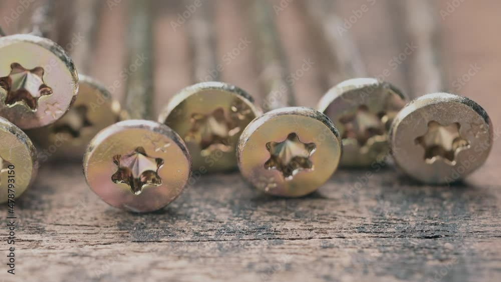 Close up shooting of parts of carpentry screws with cross head. Yellow screws on the table. Industry background. 4k footage. Close up shooting of parts of carpentry screws with cross head. Yellow screws on the table. Industry background. 4k footage.