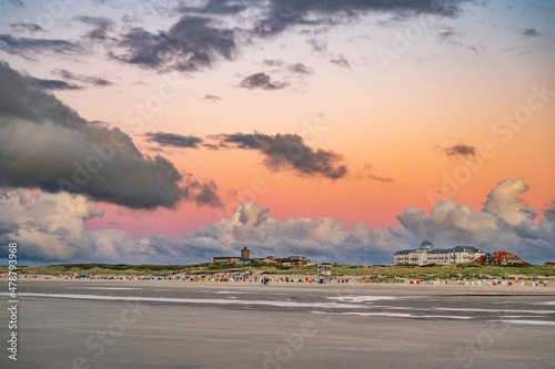 Strandabschnitt auf der Nordseeinsel Juist mit Bauten und dramatischen Abendhimmel im Sommer photo