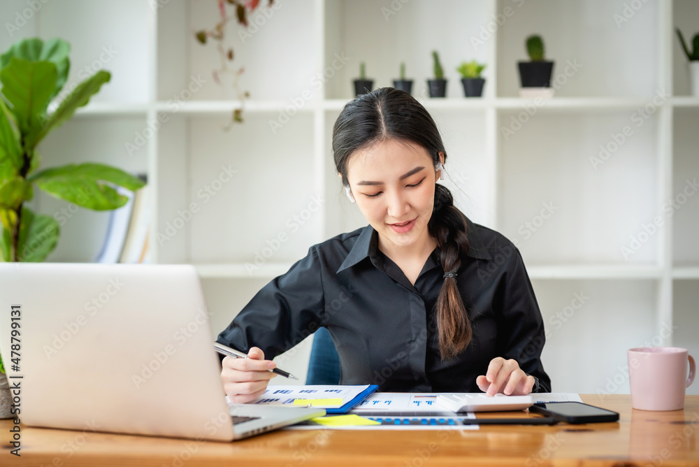 Portrait of young Asian businesswoman sitting taking notes in the office. Portrait of young Asian businesswoman sitting taking notes in the office.