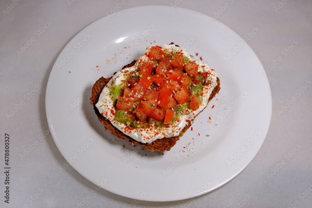 Avocado sandwiches, half of avocado, with peanuts and pumpkin seeds, tomatos on a white background Avocado sandwiches, half of avocado, with peanuts and pumpkin seeds, tomatos on a white background