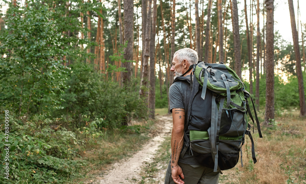 Mature caucasian man with large backpack trekking