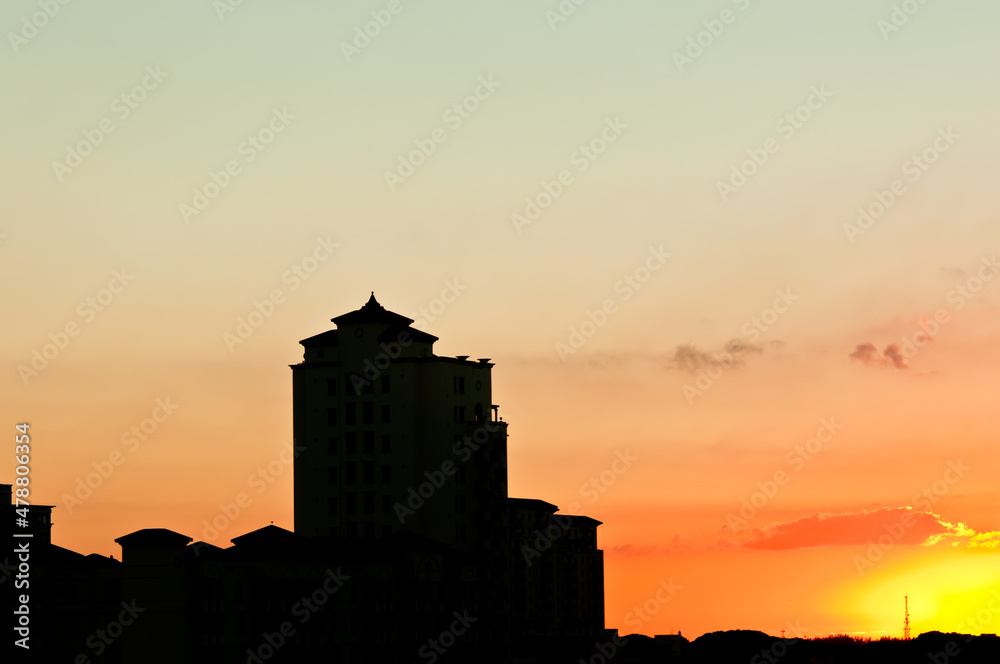 front view, far distance of a building, in silhouette at sunset, in a tropical location
