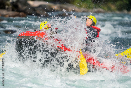 Girl are rafting in river, big watersplash over boat. Extreme sports, water activity and adrenaline concept.