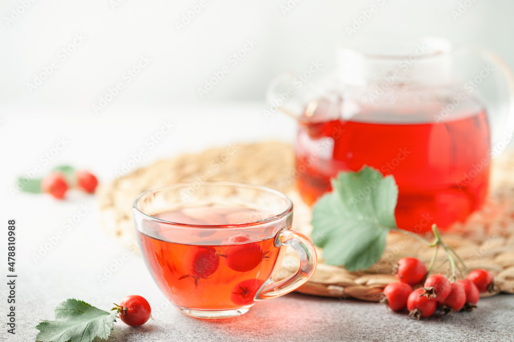 Hawthorn tea in a glass teapot and a cup on the table. Vitamin health drink.