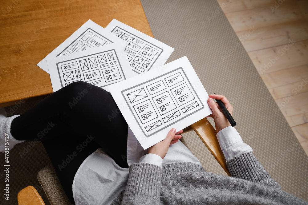 Fototapeta premium Woman designer create website design wireframe. Sketch, prototype, framework, layout future design project. UI and UX - user interface, user experience designer. Creative concept for web design studio