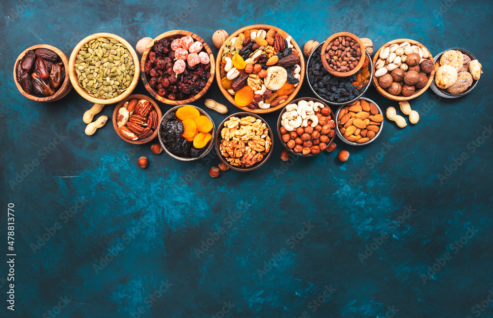 Nuts and dried fruits in assortment. Dry apricots, figs, raisins, walnuts, almonds and other. Blue table background, top view, copy space Nuts and dried fruits in assortment. Dry apricots, figs, raisins, walnuts, almonds and other. Blue table background, top view, copy space