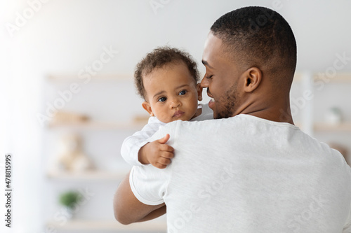 Father's love. Young afrian american dad holding his sweet infant baby photo