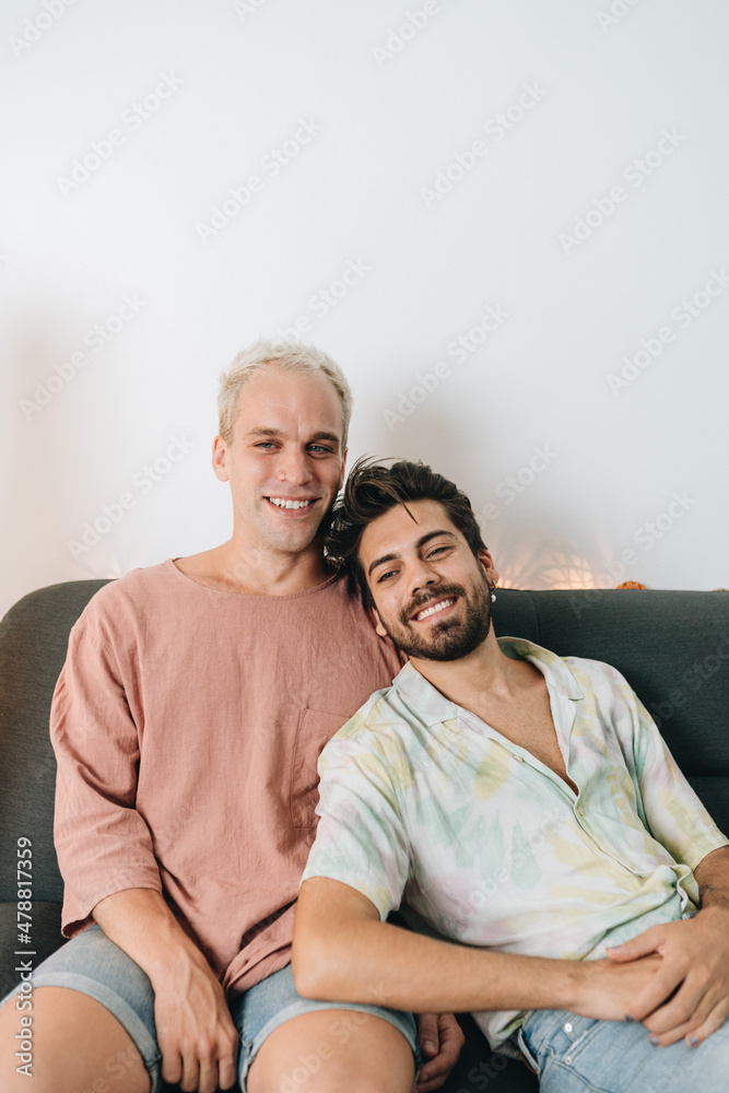 Gay happy couple sitting on sofa Gay happy couple sitting on sofa