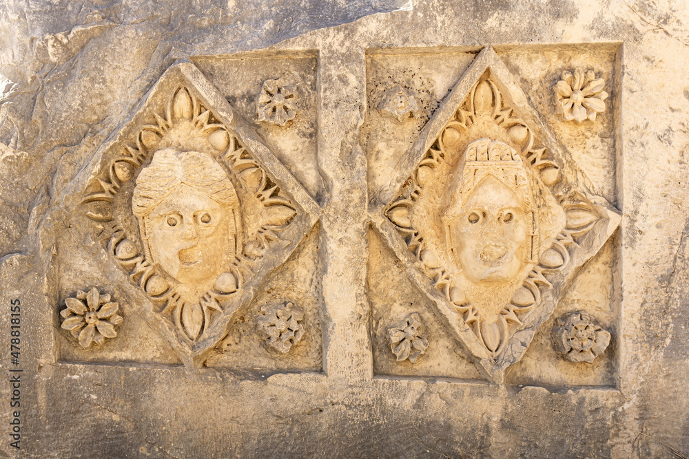 half-erased stone-cut masks on the ruins of a building in the ancient city of Mira, Turkey