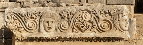 antique frieze with stone-cut faces in the ruins of the ancient city of Myra, Turkey © Evgeny