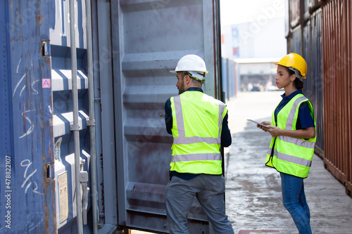 Hispanic Man worker and woman Supervisor dock cargo checking and control loading Containers box at container yard port of import and export goods. Unity and teamwork concept