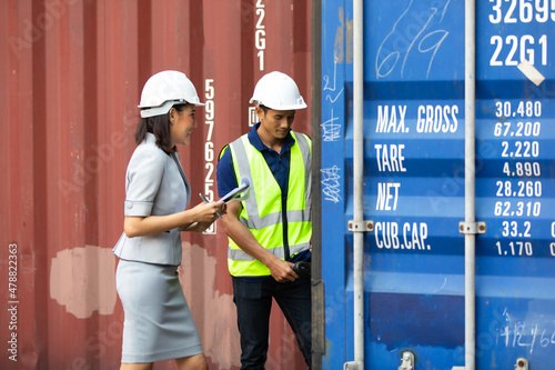 Man worker and woman Supervisor dock cargo checking and control loading Containers box at container yard port of import and export goods. Unity and teamwork concept