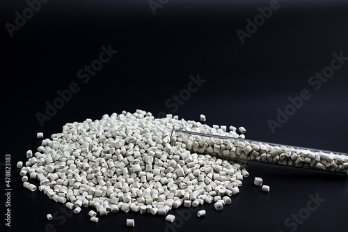 white granules of polypropylene, polyamide in a test tube. Background. Plastic and polymer industry. Microplastic products.