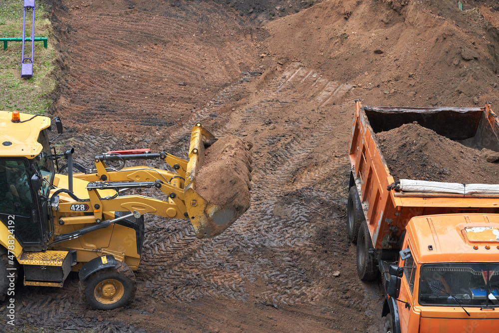 Earthworks in cramped urban conditions. The minitractor ladles the soil