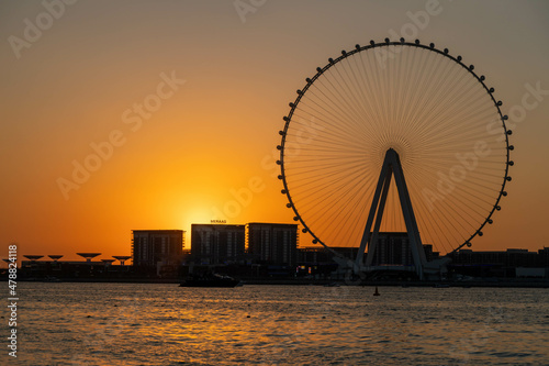 Amazing sunset colors over the sea view to the Ain Dubai, giant Ferris at artificial island Bluewaters Island  close to JBR beach. Dubai Eye fits perfect to modern UAE skyline © Igor Shaposhnikov