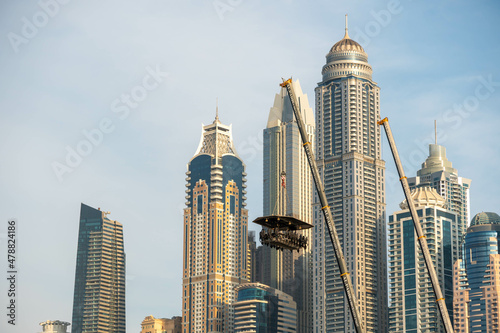 Dinner in the sky restaurant in front of Iconic Dubai Marina buildings. Modern hotels, luxury apartments, business centers and famous tourists attraction.