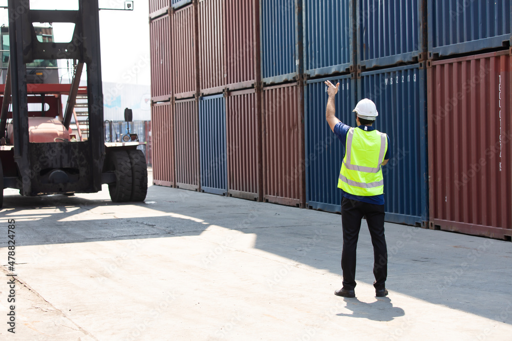 foreman manager working through a radio communication with the workers in the container yard at port of import and export goods. foreman manager working through a radio communication with the workers in the container yard at port of import and export goods.